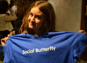 woman holding up social butterfly t-shirt