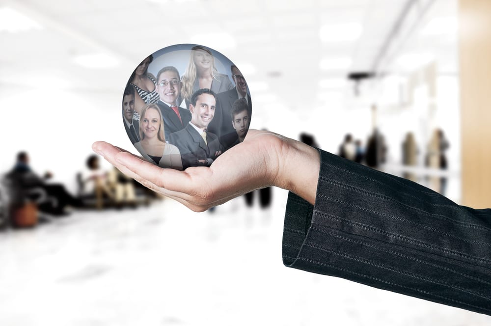 Hand holding a globe with reflection of business people