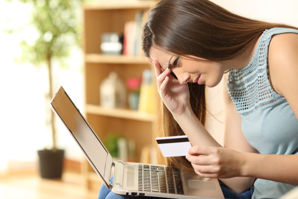 frustrated woman checking credit on computer