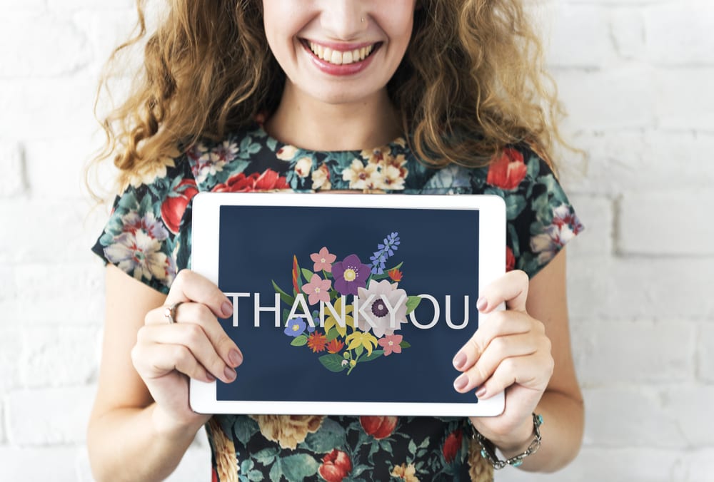 happy woman holding a thank you sign